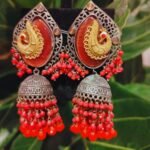 Elegant earrings adorned with with golden peacocks motifs.